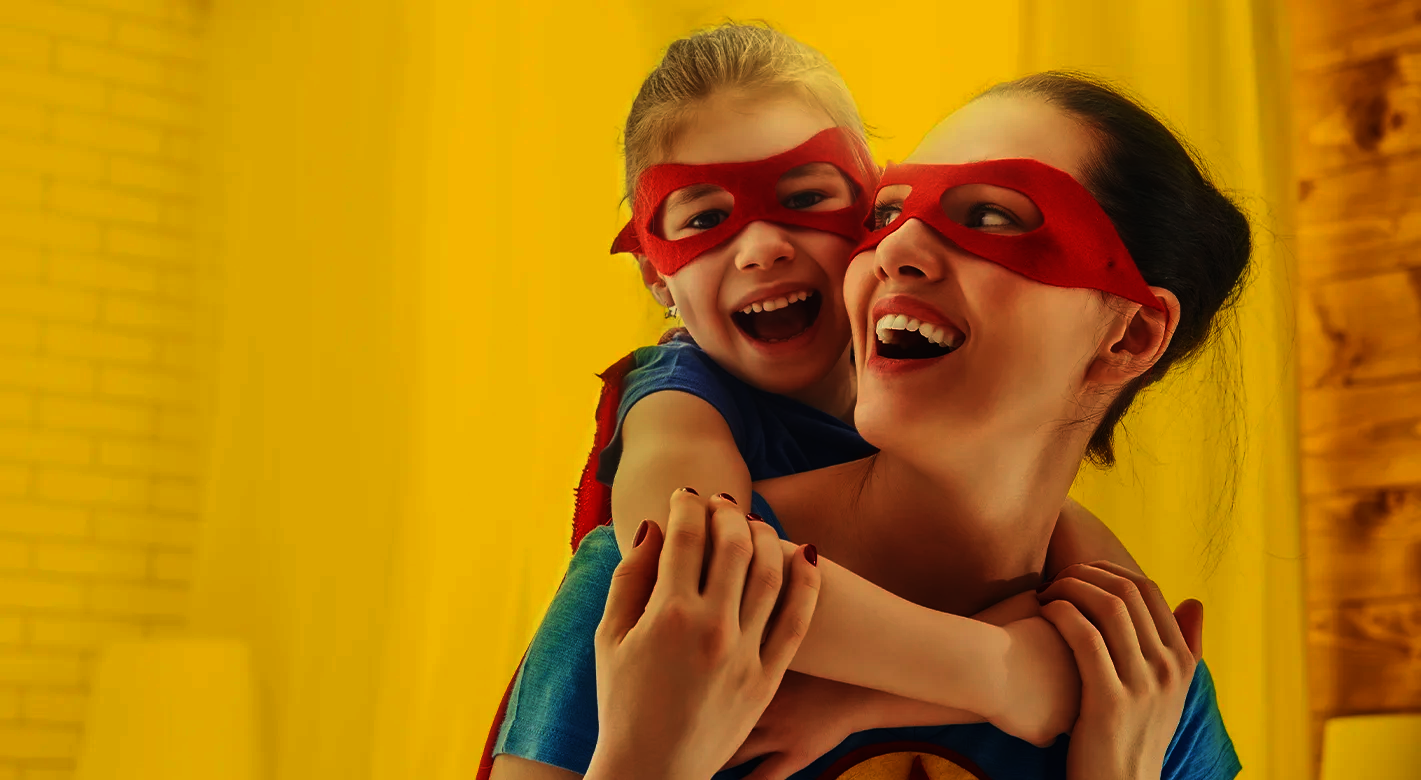 Superhelden-Momente mit Mama Mutter und Kind mit roten Masken lachen gemeinsam und spielen Superhelden als emotionales Motiv für starke Bindung und kreative Fotogeschenke zum Muttertag