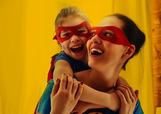 Fotogeschenke Ideen zum Muttertag Mutter und Kind mit roten Masken lachen gemeinsam und spielen Superhelden als inspirierende Szene für kreative Fotogeschenke Ideen zum Muttertag mit persönlicher Bedeutung
