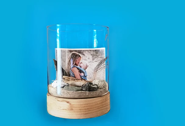 Ein Erinnerungsglas mit Foto, Sand und Stranddekoration, um ein Geldgeschenk zu verpacken.