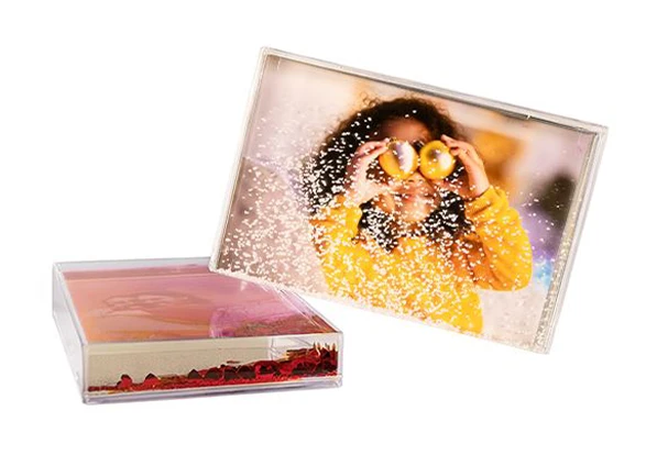 Personalisierten Schüttelrahmen gestalten Transparenter Schüttelrahmen mit Foto eines lachenden Kindes und weißen Schneekügelchen als Effekt. ORWO Fotoprodukte zu Weihnachten.