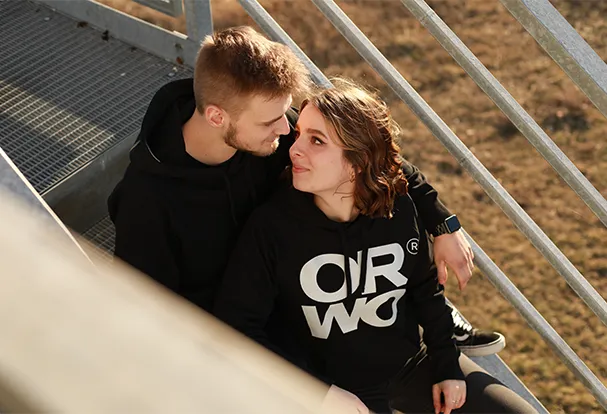 Ein Paar sitzt zusammen auf einer Treppe und genießt den Moment. Hol dir Fotografie-Tipps, um solche besonderen Augenblicke im Freien perfekt festzuhalten!