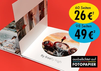 Echtfotobuch zu Festpreisen: bis 60 Seiten nur 26€², bis 98 Seiten nur 49 €² Werbeanzeige für ein Echtfotobuch mit Layflat-Bindung, das aufgeschlagen auf einem roten Untergrund liegt und Reisebilder zeigt. Zwei Rabattblöcke zeigen die Preise "60 Seiten 26 €²" & "98 Seiten 49 €², darunter befindet sich ein Qualitätssiegel.