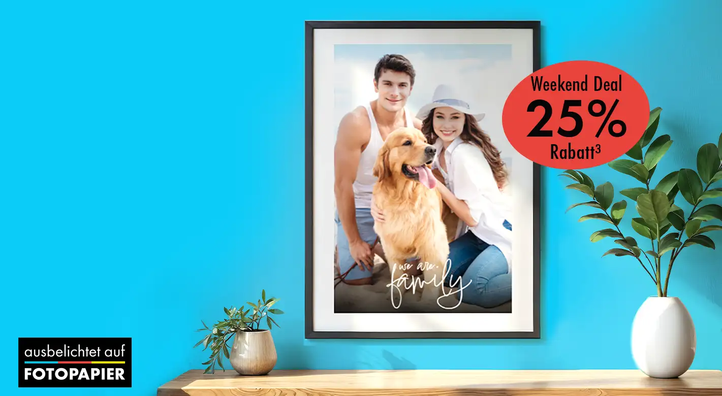 Fotoprodukte für die Wand mit eigenen Fotos gestalten und im Weekend Deal sparen Gerahmtes Wandbild mit Foto eines Paares und Hundes in einem Wohnraum mit Pflanzen, beworben als Fotoprodukt im Weekend Deal mit Rabattaktion